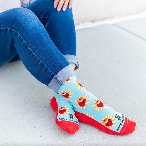 A pair of adult-sized socks with a design of the Sacred Heart of Jesus, predominantly red with blue and yellow accents.