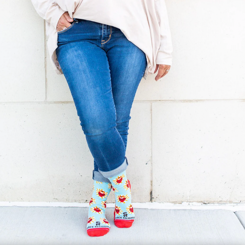 A pair of adult-sized socks with a design of the Sacred Heart of Jesus, predominantly red with blue and yellow accents.