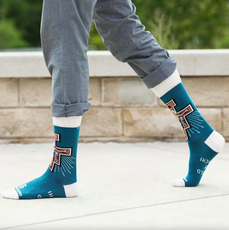 Person wear teal and white socks featuring an image of the Franciscan San Damiano crucifix