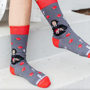 Person wearing red and gray sock featuring pictures of apples and St. Elizabeth Ann Seton