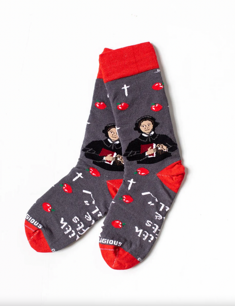 A pair of gray and red socks with an image of St. Elizabeth Ann Seton and apples, along with text and cross designs.