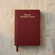 Red book titled 'Shorter Christian Prayer' on a wooden surface