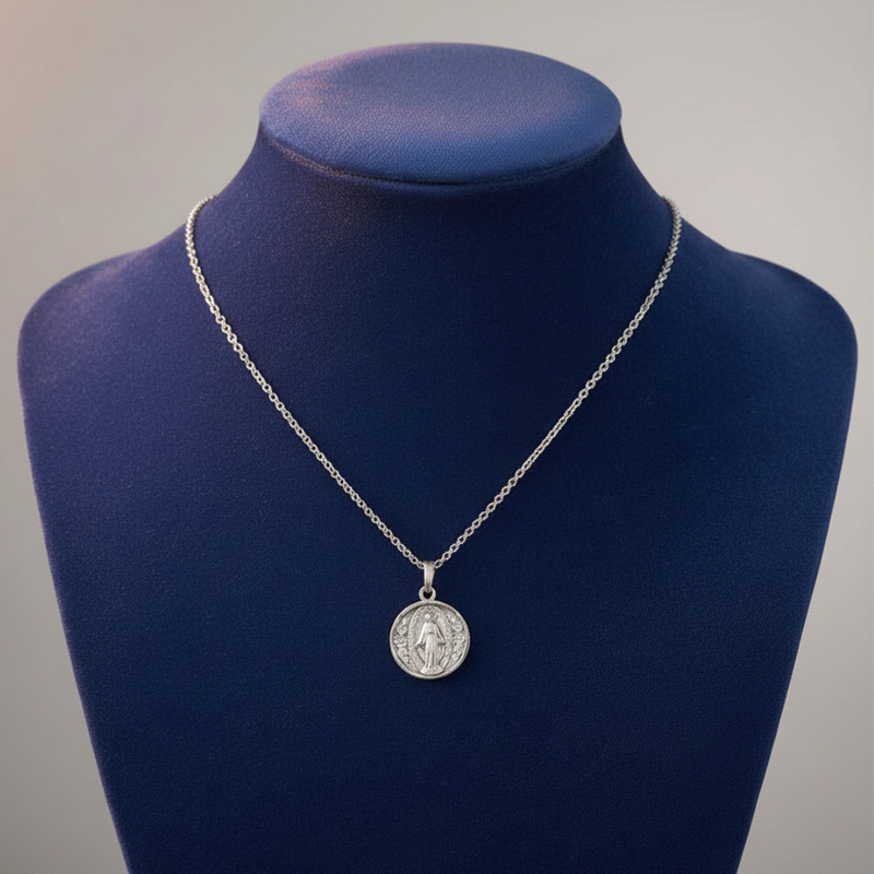 Silver necklace with a pendant on a blue mannequin bust against a gray background