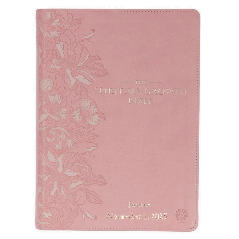 Pink Bible with floral design and text on a white background