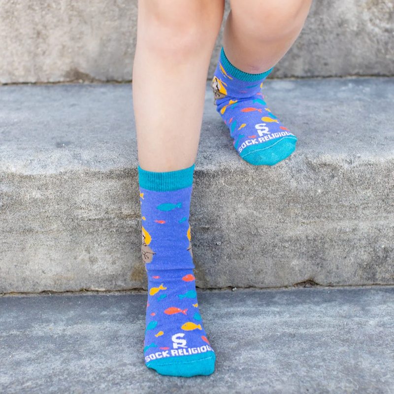 A pair of kids' socks with colorful designs and an image of St. Anthony of Padua holding the Christ Child