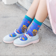 A pair of kids' socks with colorful designs and an image of St. Anthony of Padua holding the Christ Child