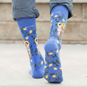 A person wearing blue crew socks featuring an image of St. Anthony of Padua holding the Infant Jesus