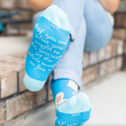 Person wearing blue socks featuring an image of St. Catherine of Siena holding a lily