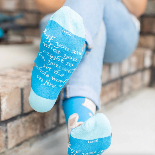 Person wearing blue socks featuring an image of St. Catherine of Siena holding a lily