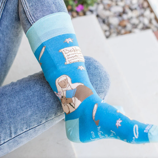 Person wearing blue socks featuring an image of St. Catherine of Siena holding a lily