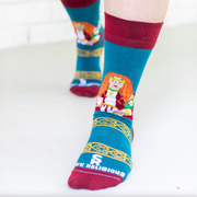 Person wearing teal and orange socks featuring an image of St. Dymphna