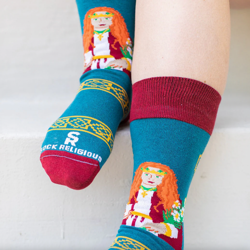 Person wearing teal and orange socks featuring an image of St. Dymphna
