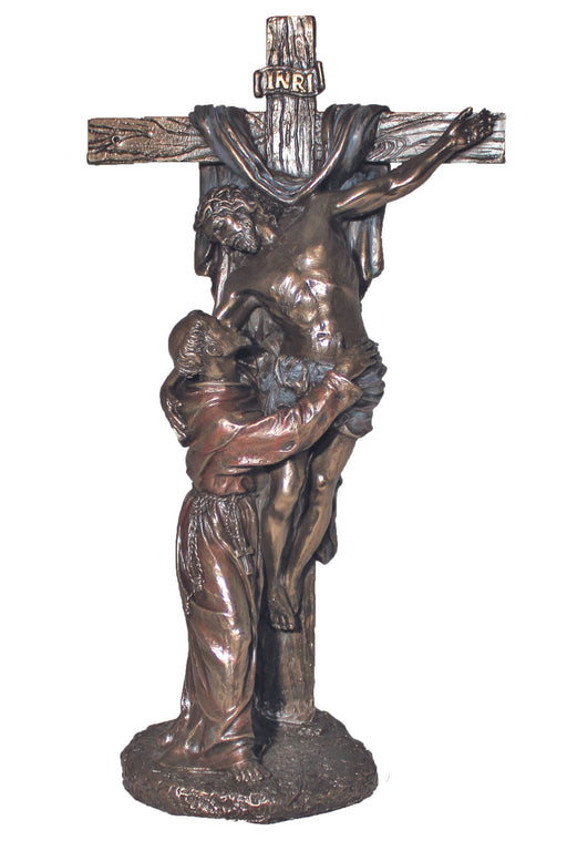 A bronze statue depicting St. Francis of Assisi in a embrace with Christ crucified on a cross, both figures slightly angled towards the viewer.