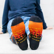 Person wearing black and orange socks featuring St. Ignatius of Loyola