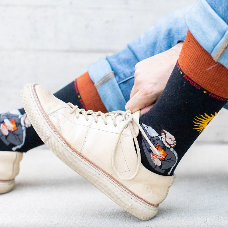 Person wearing black and orange socks featuring St. Ignatius of Loyola