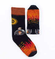 A pair of adult-sized socks with a graphic design featuring St. Ignatius of Loyola and text related to his spiritual exercises.