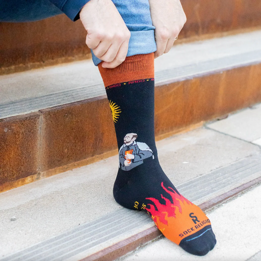 Person wearing black and orange socks featuring St. Ignatius of Loyola