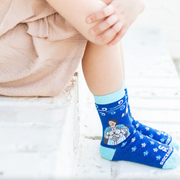 Child wearing blue crew socks featuring a fleur-de-lis pattern and an image of St. Joan of Arc holding a sword