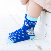 Child wearing blue crew socks featuring a fleur-de-lis pattern and an image of St. Joan of Arc holding a sword