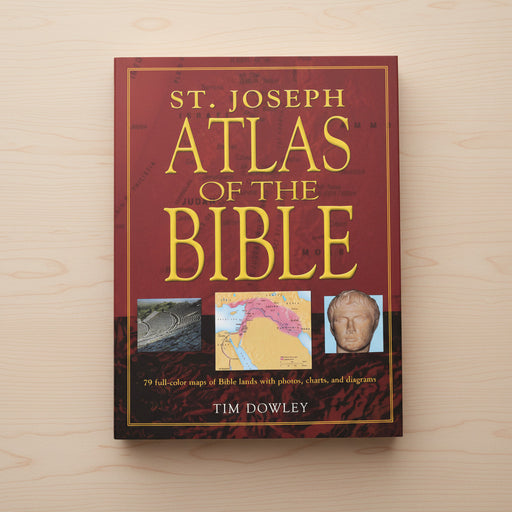 Book titled 'St. Joseph Atlas of the Bible' by Tim Dowley on a wooden surface