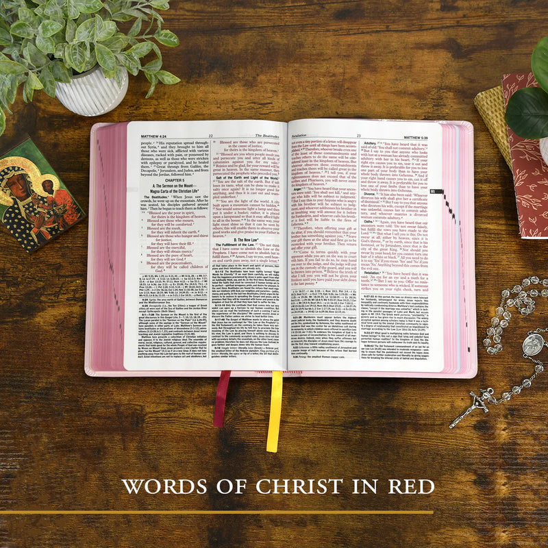 Open book with pink cover on a wooden surface, surrounded by decorative items.