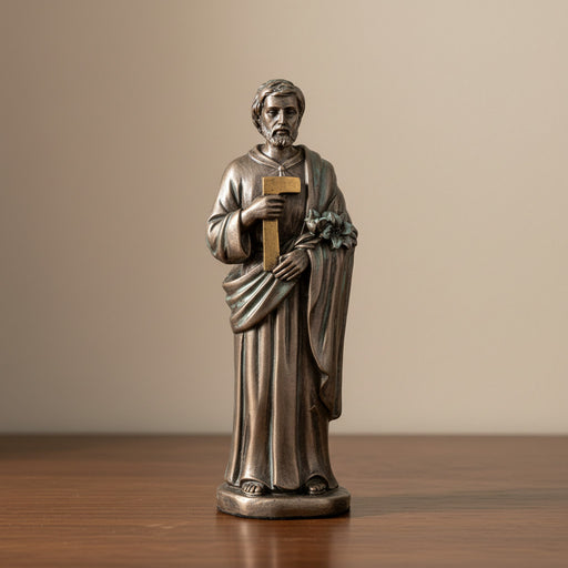 Bronze statue of St.Joseph the Worker holding a lily on a dark wood surface