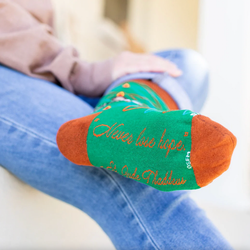 Person wearing vibrant green socks with an image of St. Jude