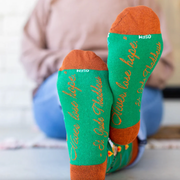 Person wearing vibrant green socks with an image of St. Jude