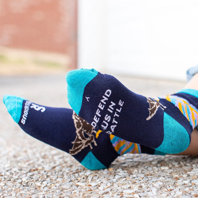 Colorful socks with images of St. Michael the Archangel worn by a child on a light background
