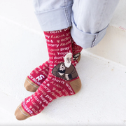Person wearing red socks featuring an image of St. Padre Pio and text 'pray, hope, & don't worry'