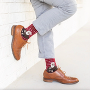 Person wearing red socks featuring an image of St. Padre Pio and text 'pray, hope, & don't worry'