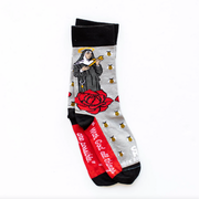 A pair of adult-sized socks featuring an illustration of St. Rita with a red rose and bees on her head, with the text 'With God, all things are possible.