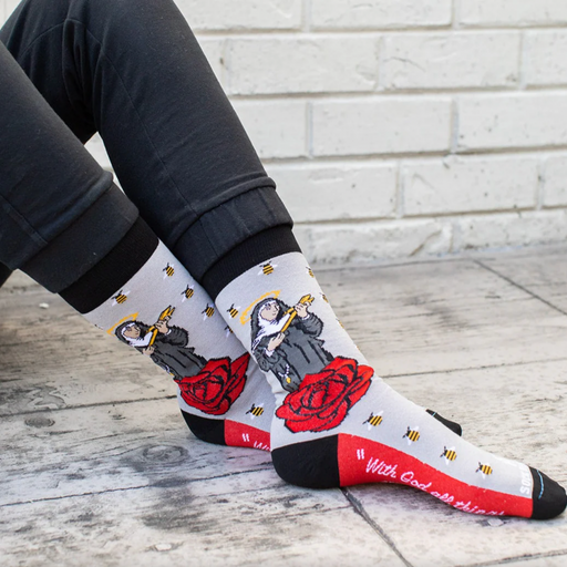 Person wearing gray socks with vibrant red roses and an image of St. Rita holding a cross.