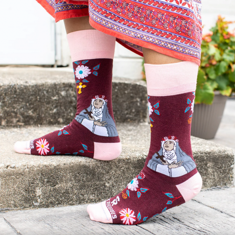 Person wearing burgundy and pink floral crew socks with an imagine of St. Rose of Lima.