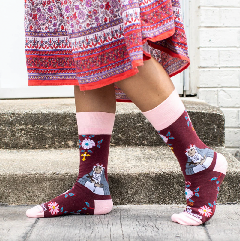 Person wearing burgundy and pink floral crew socks with an imagine of St. Rose of Lima.