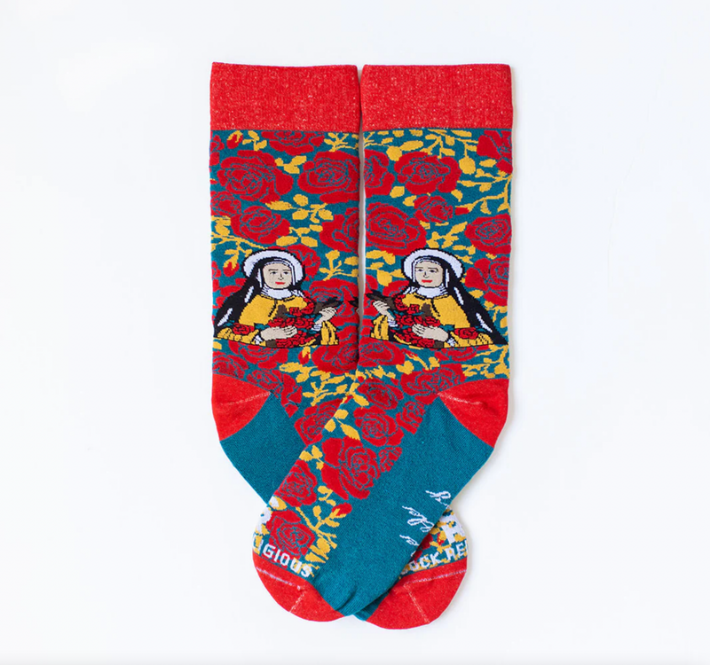 Person wearing red and yellow floral rose socks featuring an image of St. Therese the Little Flower