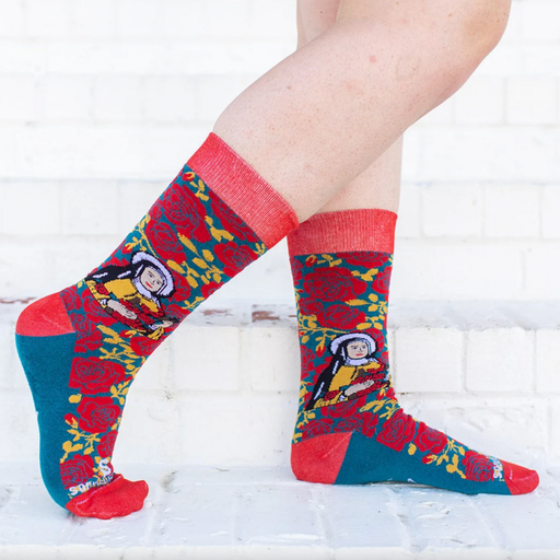 Person wearing red and yellow floral rose socks featuring an image of St. Therese the Little Flower