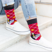 Person wearing bright red socks with an image of St. Thomas Aquinas holding an open book