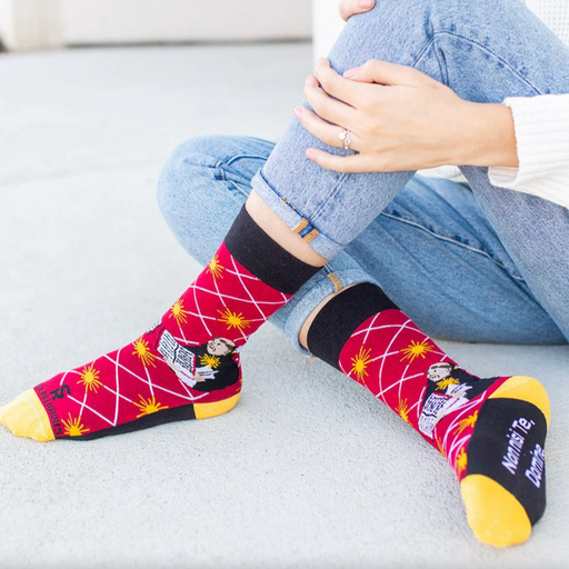 Person wearing bright red socks with an image of St. Thomas Aquinas holding an open book