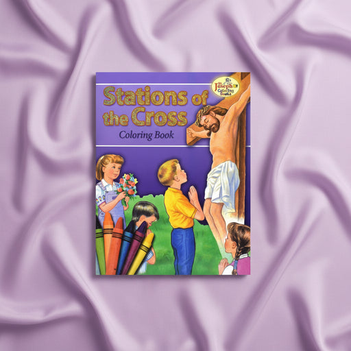 Coloring book titled 'Stations of the Cross' on a purple fabric background
