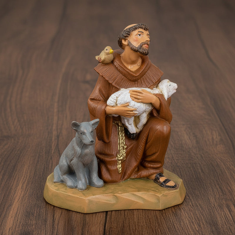 Figurine of St. Francis of Assisi holding a lamb on a wood surface