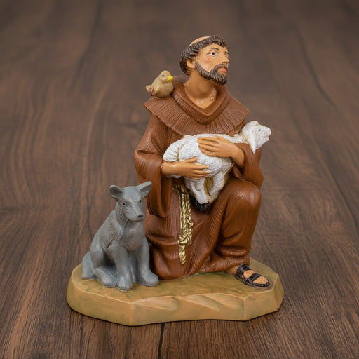 Figurine of St. Francis of Assisi holding a lamb on a wood surface