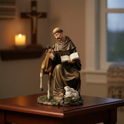 Statue of St. Francis of Assisi seated with animals on a wood table.