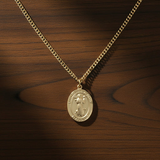 Gold St. Francis of Assisi necklace and chain on a wood surface