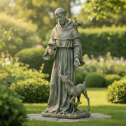 Statue of a religious figure with a bird and a deer in a garden setting