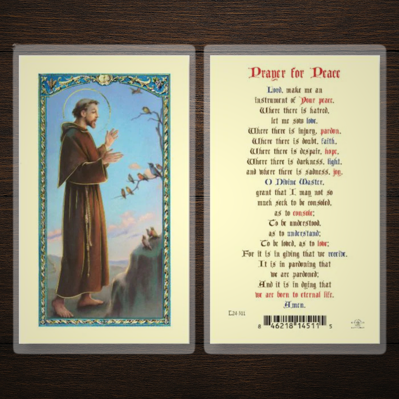 Prayer card with Saint Francis illustration and text on a wooden surface