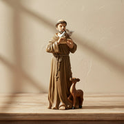Miniature St. Francis of Assisi statue on a wood surface