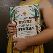 Person holding a book titled 'The Story of All Stories' by Emily Simpson Chapman.