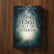 Book titled 'Making Sense Out of Suffering' by Peter Kreeft on a wooden surface