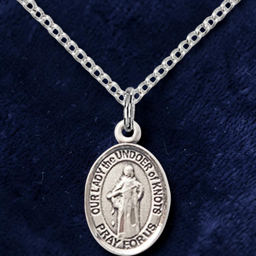 Silver pendant necklace on a dark blue fabric background